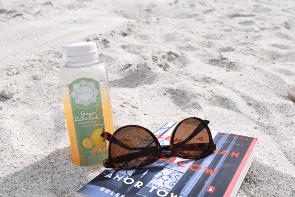 Juice, sunglasses and a book in the sand at St. Pete Beach